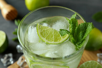 Glass of mojito cocktail on table with ingredients, close up
