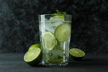 Glass of mojito cocktail and ingredient on dark wooden table