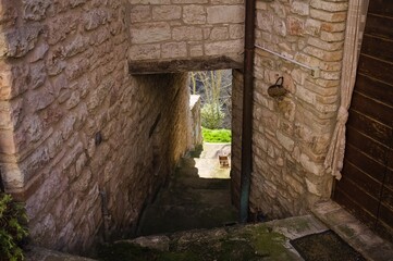 Fototapeta na wymiar An alley of a medieval village with a tunnel under stone buildings (Marche, Italy, Europe)