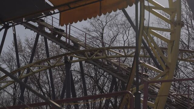 An abandoned, rust-covered roller coaster ride in an abandoned amusement park.