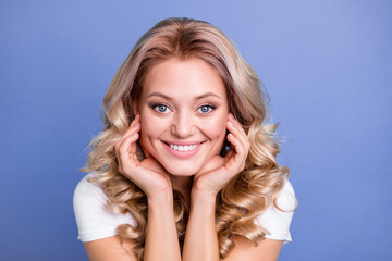Photo of young happy smiling positive pretty lovely girl with long curly blonde hair isolated on blue color background