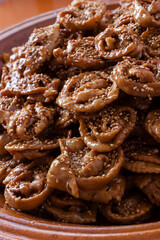 Vertical shot of fresh Chebakia sweets on a traditional moroccan big size ceramics plate on a wooden table with natural light. 
