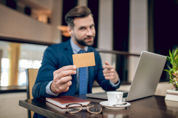 Businessman in a nice suit showing a credit card
