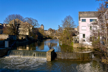 Little waterfall and buildings on the bank of river Sarthe at Alençon of the Lower Normandy region in France