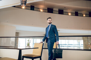 Buisnessman in a blue suit with a black suitcase