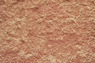 Red-orange painted wall with cinder block texture. Abstract interior background.