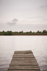 Obraz premium Evening view of the wooden fishing bridge for fishing. Empty boat dock on a river or lake.