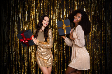 Photo of two positive carefree chic ladies hold presents dance wear glossy outfit isolated tinsel background © deagreez