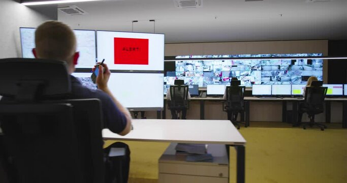 Security guards watching video monitoring surveillance security system im modern facility with high end protection systems and technology