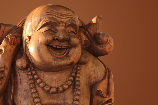 Hotei or the laughing Buddha is a wooden statue on a brown background..