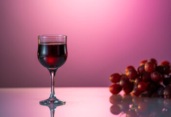One glasse of red wine and bottle on the fantastic pink background