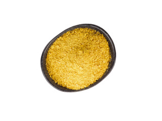 Nutritional yeast in black bowl isolated on white background.
