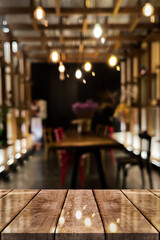 Empty wooden table top with lights bokeh on blur restaurant background.