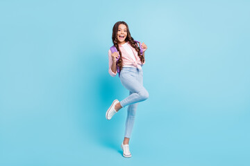 Full size photo of young happy excited funky positive good mood schoolgirl wear violet bag isolated on blue color background