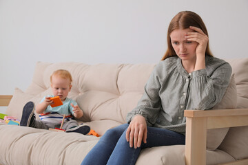 Depressed single mother with child in living room