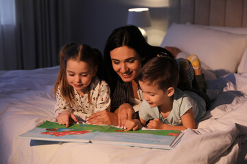 Mother reading bedtime story to her children at home