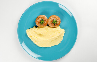 Crushed potatoes with two chicken cutlets in a plate