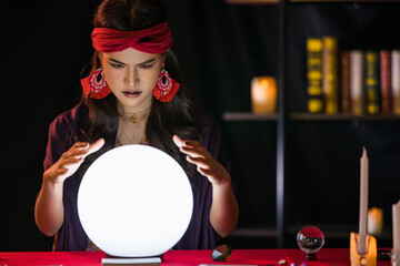 Asian fortune teller looking at crystal ball