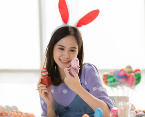 Easter Egg Festival. Asian women smiling faces. Put a bow tie on the head Hand painted various color easter eggs in white room, easter egg festival idea