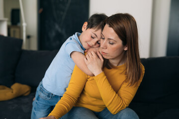 boy hugging his depressed mother