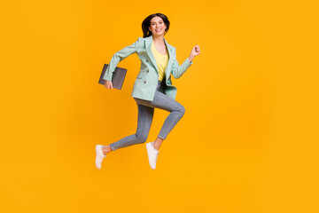 Fototapeta na wymiar Full size profile side photo of young happy smiling girl jumping running with laptop in hand isolated on yellow color background