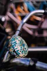 Nicely decorated bicycle bell on the handlebars of a bicycle somewhere in the city.