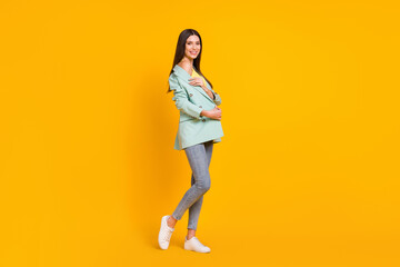 Fototapeta na wymiar Full size photo of young smiling positive good mood lovely pretty girl showing shoulder isolated on yellow color background