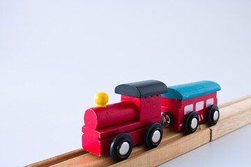 Wooden toy train on wooden train tracks, close up, isolated on white background with copy space
