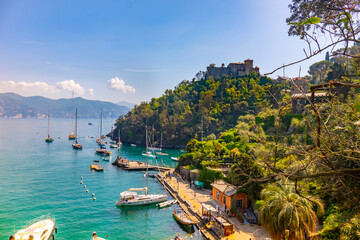 beautiful colorful view Gulf of Portofino Italy with castle Brown in background and boats anchored to small picturesque harbor .