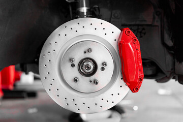 close up of a car brake system red caliper