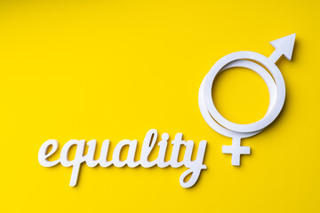 Gender equality symbol on yellow background and word equality, copy-space