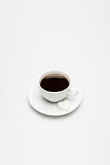 cup of fresh coffee and sugar cubes on saucer on white