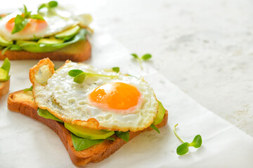 Tasty sandwich with egg and avocado on table