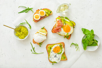 Tasty sandwiches with egg and avocado on white background