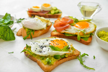 Tasty sandwiches with egg and avocado on table