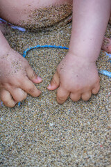 Father with little son have fun playing in the sand on Crete island, Greece