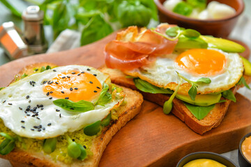 Tasty sandwiches with egg and avocado on board, closeup