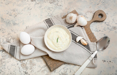 Plate with garlic sauce and ingredients on grey background