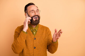 Photo of positive cheerful mature man call smartphone say joke laugh wear sweater isolated over...