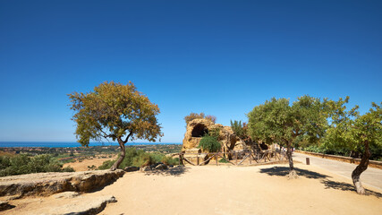 Fototapeta na wymiar Ruins of ancient protective wall of Akragas town.Valley of Temples, Agrigento, Sicily island in South Italy. Panoramic image with single tree.