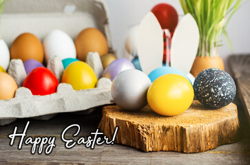 Happy Easter card. colored blue, beige, white Easter eggs in nest top view on wooden background...
