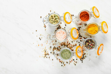 Jars with different spices on white background