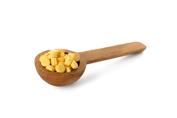 Spoon with folic acid pills on white background