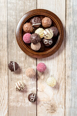 Chocolates On the plate on the table. View from above. Gift wrap. Wooden background. Close-up. Place for your text.