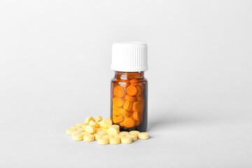 Bottle with folic acid pills on light background