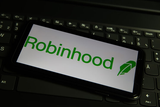 Viersen, Germany - March 1. 2021: Closeup of mobile phone screen with logo lettering of robinhood online broker service on computer keyboard