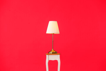 Stand with stylish lamp on color background
