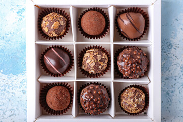 Box with sweet chocolate candies on color background