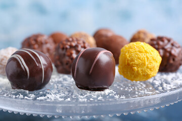 Dessert stand with sweet chocolate candies on color background, closeup