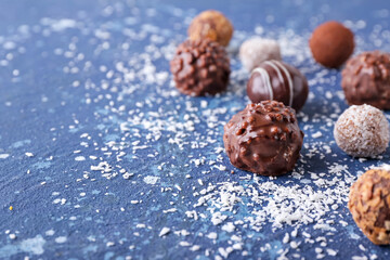 Sweet chocolate candies on color background